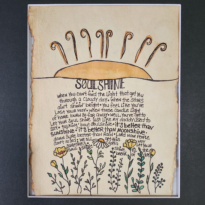 Pu&ograve; includere: Un'illustrazione disegnata a mano di un sole con le parole "SoulShine" scritte in corsivo. Il testo sotto il sole dice: "Quando non riesci a trovare la luce che ti ha portato attraverso una giornata nuvolosa. Quando le stelle non brillano. Ti senti come se ti fossi perso. Quando quelle luci di candela di casa bruciano cos&igrave; lontano. Beh, devi lasciare che la tua anima brilli come faceva mio padre. Parlando di luce dell'anima. &Egrave; meglio del sole. &Egrave; meglio della luna. Accidenti, &egrave; meglio della pioggia. Signore, ora la gente non se ne preoccupa. Dobbiamo tutti ottenere questa luce dell'anima. Brilla fino all'alba."