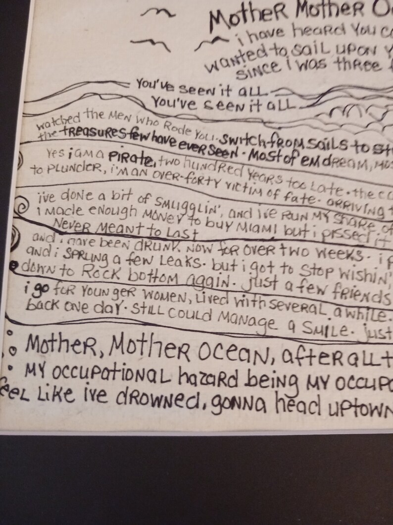 May include: A white paper print featuring black hand-lettered lyrics from the song A Pirate Looks at Forty. The text includes lines such as Mother Mother Ocean, I am a pirate, and I've done a bit of smugglin', arranged with wavy line illustrations.