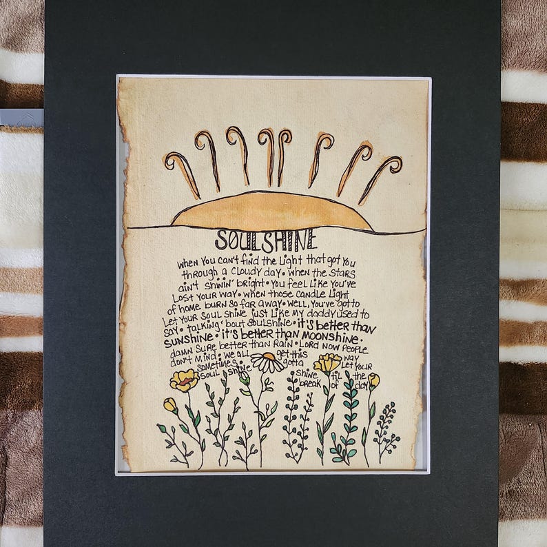 Pu&ograve; includere: Un'illustrazione disegnata a mano di un sole con le parole "SOULSHINE" scritte in nero. Il testo sotto il sole dice "when you can't find the light that got you through a cloudy day. when the stars ain't shinin' bright you feel like you've lost your way when those candle light of home burn so far away well, you've got to say talking 'bout soulshine - it's better than sunshine - it's better than moonshine. dawn sure better than rain lord now people don't mind we all gotta let your shine til the break of day"