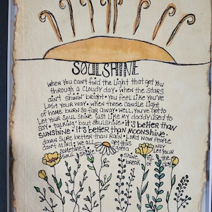 Pu&ograve; includere: Un'illustrazione disegnata a mano di un sole con le parole "SOULSHINE" scritte in nero. Il testo sotto il sole dice: "Quando non riesci a trovare la luce che ti ha portato attraverso una giornata nuvolosa. Quando le stelle non brillano. Ti senti come se ti fossi perso. Quando quelle luci di candela di casa bruciano cos&igrave; lontano. Bene, devi lasciare che la tua anima brilli come faceva mio padre. Parlando di anima. &Egrave; meglio del sole. &Egrave; meglio della luna. Certo che &egrave; meglio della pioggia. Signore, ora la gente non se ne preoccupa. Dobbiamo tutti brillare. Lascia che la tua anima brilli. Alba."