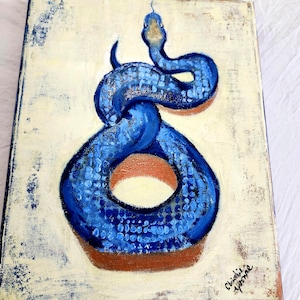 May include: A rectangular canvas painting featuring a vibrant blue snake coiled into a circular shape against a distressed cream-colored background. The snake has textured scales and a raised head. The artist's signature is visible in the bottom corner.