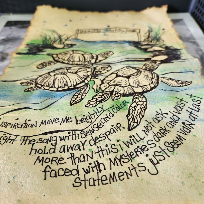 Op de afbeelding: Een stuk perkamentpapier met verbrande randen met een aquarel- en inktillustratie van drie zeeschildpadden die in blauw en groen water zwemmen. Het kunstwerk bevat handgeschreven tekst: Inspiration move me brightly, light the song with sense and color, hold away despair, more than this I will not ask, faced with mysteries dark and vast, statements just seem vain at last.