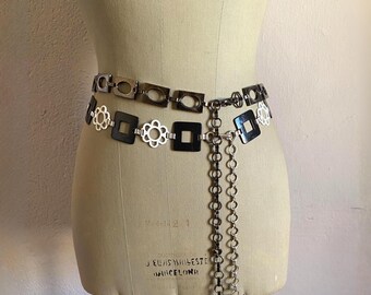 Conjunto de cinto vintage dos anos 70 com corrente metálica, elos geométricos florais, acessório mod preto e branco.