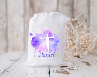 May include: White drawstring bag with a purple watercolour design of a person on rings. The bag has the name "Daniel" printed on it.