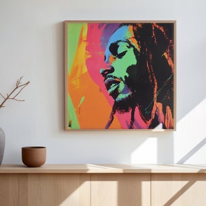 Puede incluir: Una impresión enmarcada de un retrato colorido de un hombre con rastas. El retrato está en un estilo pop art con colores brillantes como rojo, naranja, amarillo, verde y azul. La impresión está colgada en una pared blanca sobre un gabinete de madera.