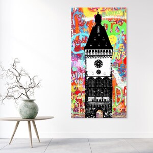 Puede incluir: Una ilustraci&oacute;n en blanco y negro de una torre del reloj con un fondo de graffiti colorido. El graffiti incluye palabras como "ROAD", "WAYS", "VIVIR" y "LIBERTAD".