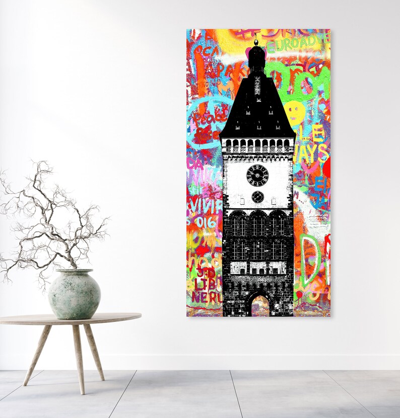 Puede incluir: Una ilustraci&oacute;n en blanco y negro de una torre del reloj con un fondo de graffiti colorido. El graffiti incluye palabras como "ROAD", "WAYS", "VIVIR" y "LIBERTAD".