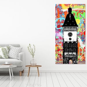 Puede incluir: Una ilustraci&oacute;n en blanco y negro de una torre del reloj con una esfera del reloj y un techo puntiagudo. La torre est&aacute; sobre un fondo colorido de grafitis con palabras y frases en diferentes idiomas.