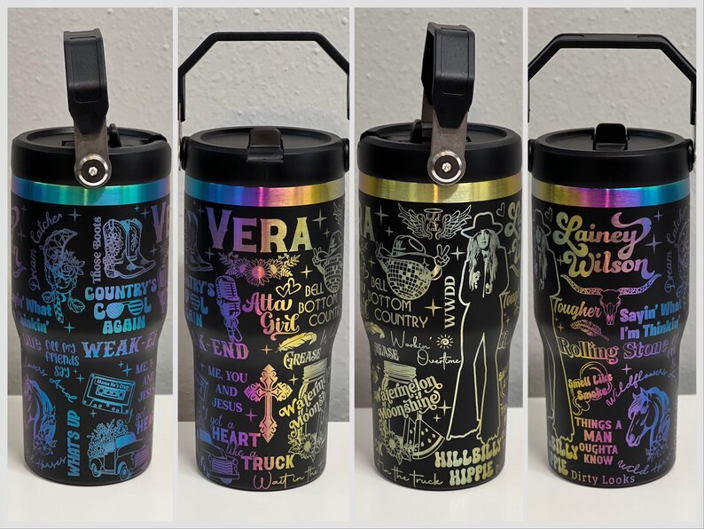 Pode incluir: Quatro copos de a&ccedil;o inoxid&aacute;vel preto com detalhes arco-&iacute;ris coloridos e designs variados. Os copos apresentam diferentes textos e gr&aacute;ficos, incluindo "Vera", "Atta Girl", "Hillbilly Hippie" e "Lainey Wilson".