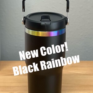 Pode incluir: Caneca de viagem preta com uma faixa arco-&iacute;ris ao redor do meio e uma al&ccedil;a preta. A caneca tem uma tampa preta com uma tampa dobr&aacute;vel. O texto "New Color! Black Rainbow" est&aacute; sobreposto &agrave; imagem.