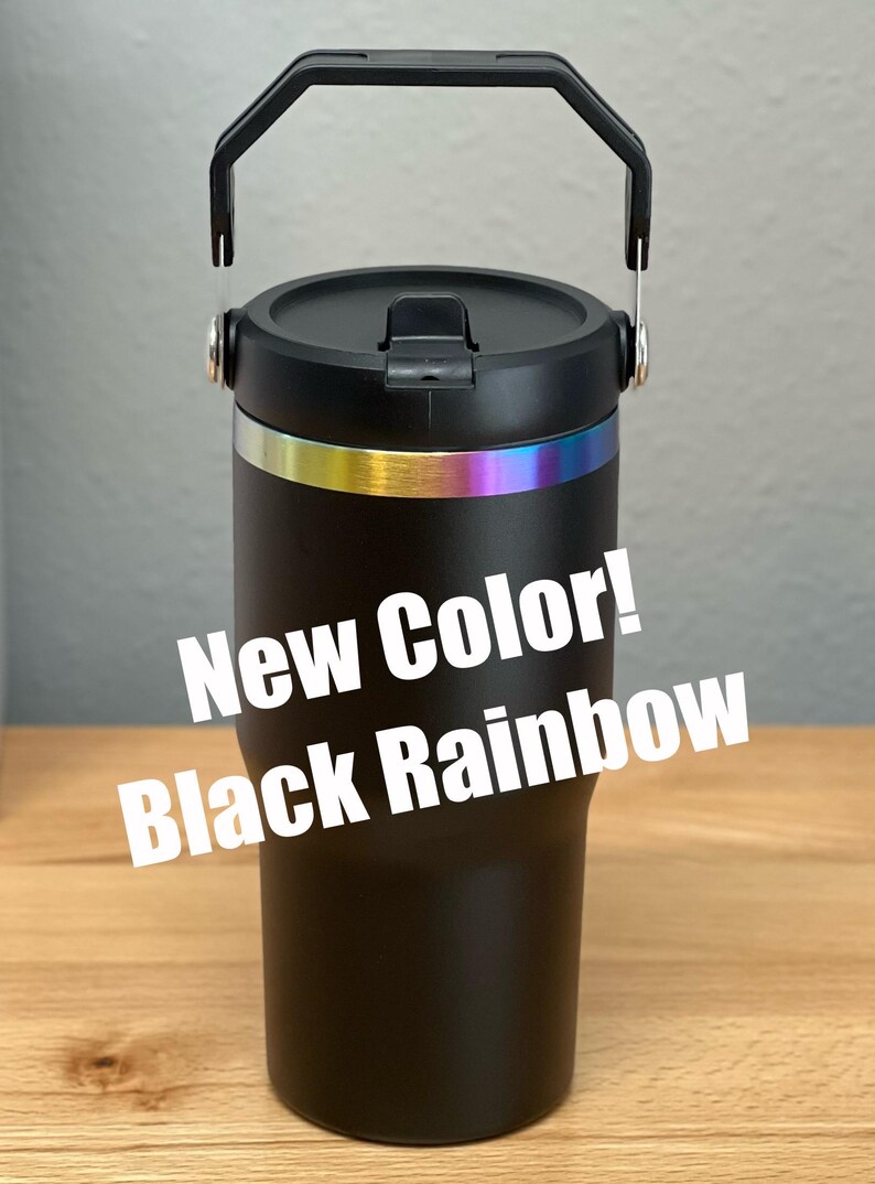 Pode incluir: Caneca de viagem preta com uma faixa arco-&iacute;ris ao redor do meio e uma al&ccedil;a preta. A caneca tem uma tampa preta com uma tampa dobr&aacute;vel. O texto "New Color! Black Rainbow" est&aacute; sobreposto &agrave; imagem.