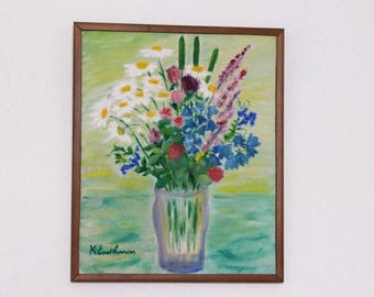 May include: A framed painting of a floral arrangement in a glass vase. The bouquet features white daisies, blue delphiniums, pink and red flowers, and green foliage. The background is a light green and yellow. The painting is signed.