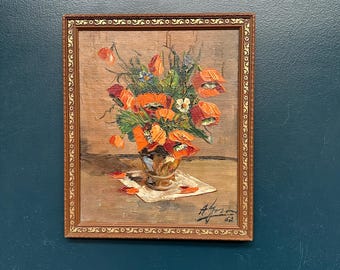 May include: An oil painting in a decorative gold-toned frame depicting a bouquet of vibrant orange poppies in a metallic vase. The artwork features textured brushstrokes, scattered petals on a surface, and a signature with the year 62 in the corner.