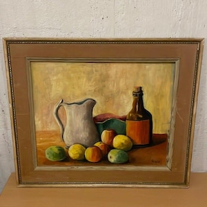 May include: Oil painting in a wooden frame depicts a still life with a white pitcher, a brown bottle, a green and red bowl, and several fruits. The fruits include apples and lemons. The background is a warm, golden color.