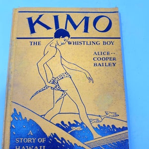 May include: A yellow book cover with the title "Kimo, The Whistling Boy" by Alice Cooper Bailey. The cover features a black and white illustration of a person surfing on a wave.