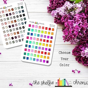 May include: Two sheets of rectangular stickers featuring rows of miniature book icons. One sheet displays muted, neutral tones, while the other features vibrant, rainbow-colored books. Each sheet includes the text The Shelfie Chronicles and AFB 108.