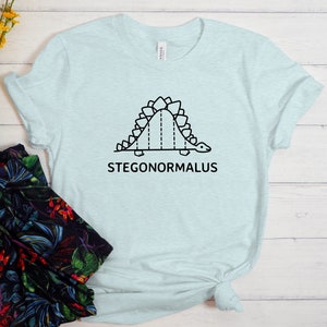 May include: A light blue t-shirt with a black line drawing of a dinosaur with the text "STEGONORMALUS" underneath.