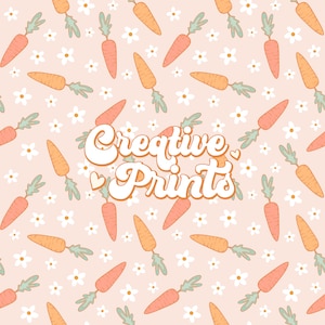 以下が含まれることがあります： 明るいピーチ色の背景に、緑の葉と白い花が付いたオレンジ色のニンジンが繰り返されるパターン。 「Creative Prints」の文字は、ハートマーク付きのレトロなフォントです。