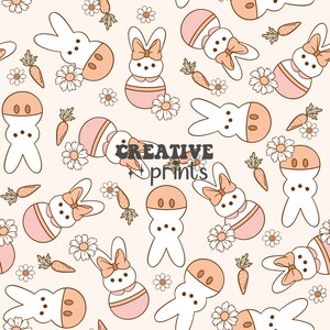 Peut inclure: Un motif sans couture représentant des guimauves en forme de lapin blanc avec des accents roses et bruns, entourées de marguerites blanches et de carottes orange sur un fond rose clair. Le texte "CREATIVE prints" est au centre du motif.