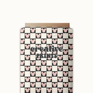 Pode incluir: Uma sacola de presente de papel castanho com um padrão xadrez preto e branco com cabeças de Mickey Mouse cor-de-rosa. A sacola tem o texto "creative PRINTS" impresso.