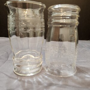 Puede incluir: Dos vasos de beber de vidrio transparente con un dise&ntilde;o en relieve. Los vasos est&aacute;n vac&iacute;os y tienen un aspecto esmerilado.