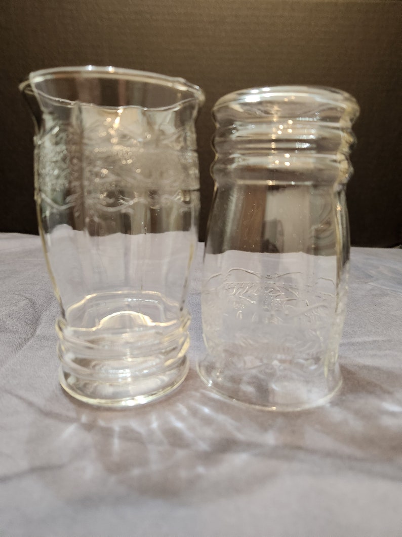 Puede incluir: Dos vasos de beber de vidrio transparente con un dise&ntilde;o en relieve. Los vasos est&aacute;n vac&iacute;os y tienen un aspecto esmerilado.
