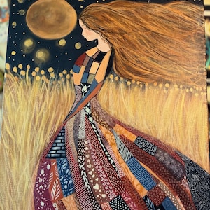 Op de afbeelding: Een schilderij van een vrouw met lang, golvend rood haar, die een kleurrijk patchworkjurk draagt. De vrouw staat in een veld met hoog, gouden gras onder een donkere nachthemel met een grote, gouden maan en sterren.