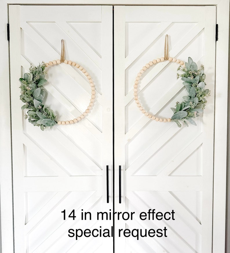 May include: Two 14-inch wood bead wreaths with greenery on a white door with a chevron pattern. The text "14 in mirror effect special request" is at the bottom of the image.
