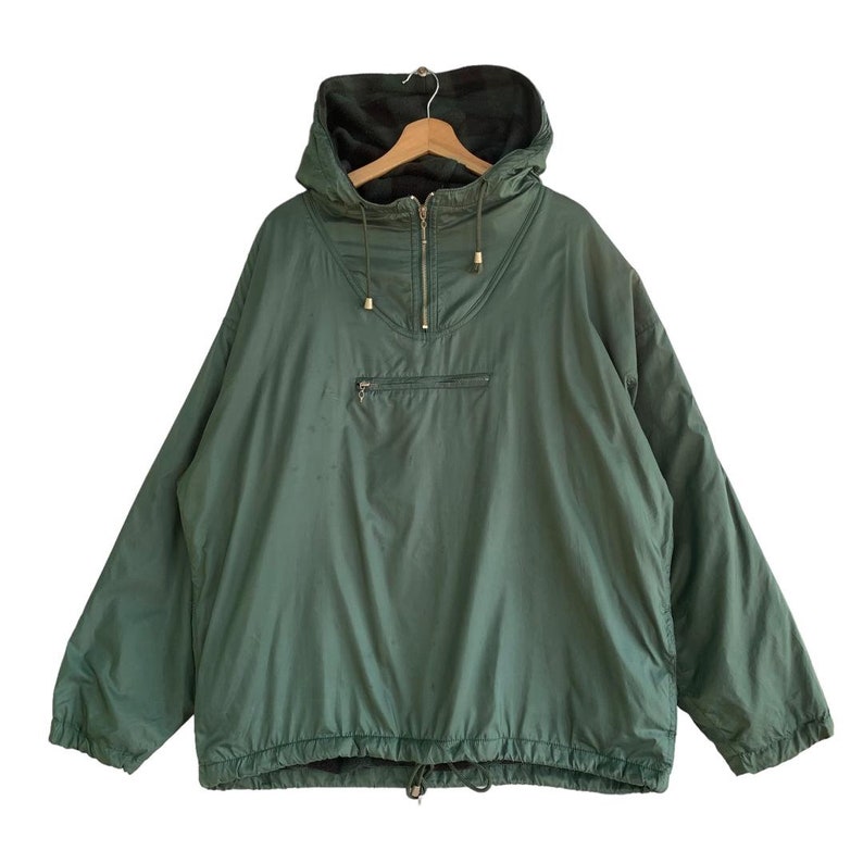 May include: A dark green hooded jacket with a half-zip closure and a drawstring at the bottom.