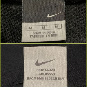 May include: White tag with black Nike swoosh logo and text "RN# 56323 CA# 05659 RFC# NME 920220 KL4".