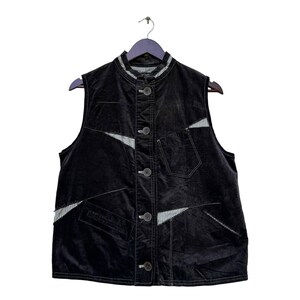 May include: A black velvet waistcoat with a button-up front and a contrasting white and black striped fabric detail. The waistcoat has multiple pockets and a stand-up collar.