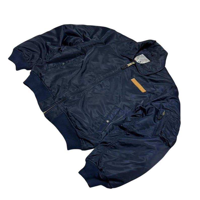 Vintage Avirex MA 1 Bomber Jacket Navy USA Flight Jacket 90s Streetwear Military Jacket Classic Zip Up Nylon Bomber Coat For Men And Women Rare Avirex USA Outerwear Piece With Iconic Back Logo Design.