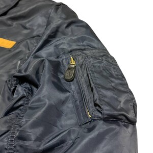 Vintage Avirex MA 1 Bomber Jacket Navy USA Flight Jacket 90s Streetwear Military Jacket Classic Zip Up Nylon Bomber Coat For Men And Women Rare Avirex USA Outerwear Piece With Iconic Back Logo Design.