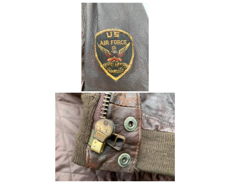 May include: Close-up of a brown leather jacket with a zipper and a US Air Force patch. The patch is embroidered with a winged eagle and the words "US Air Force".