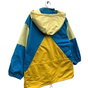 May include: A blue, yellow, and light yellow hooded jacket with a drawstring at the bottom.