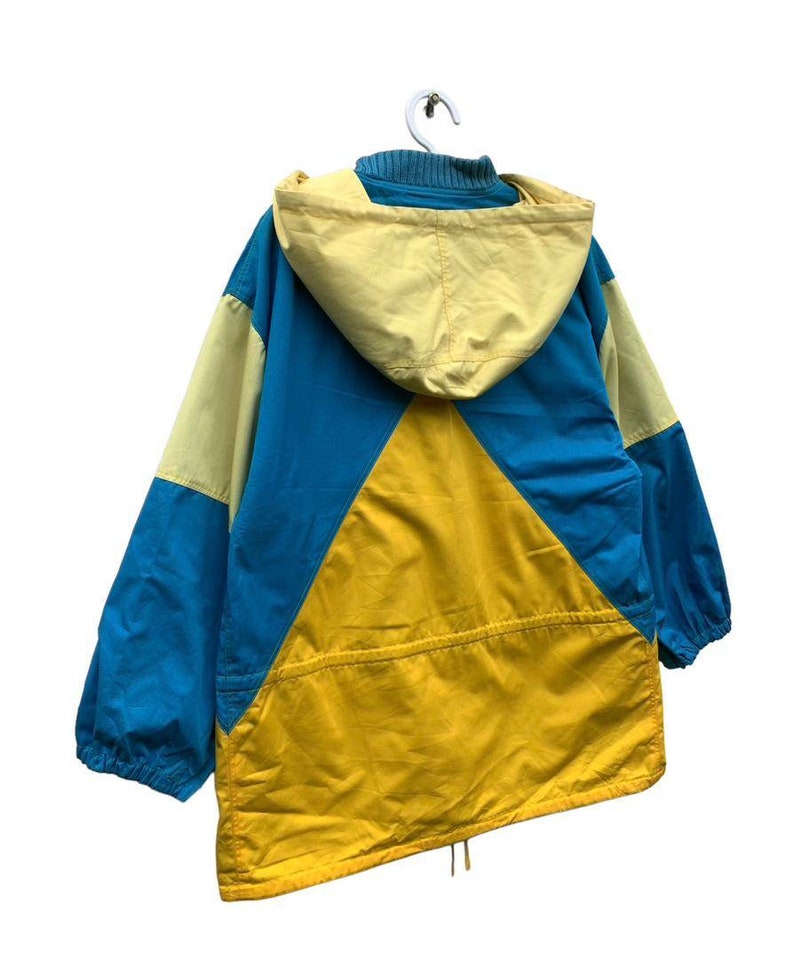 May include: A blue, yellow, and light yellow hooded jacket with a drawstring at the bottom.