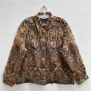 May include: A brown and tan patterned button-up shirt with long sleeves. The shirt has a leopard print and a paisley design.
