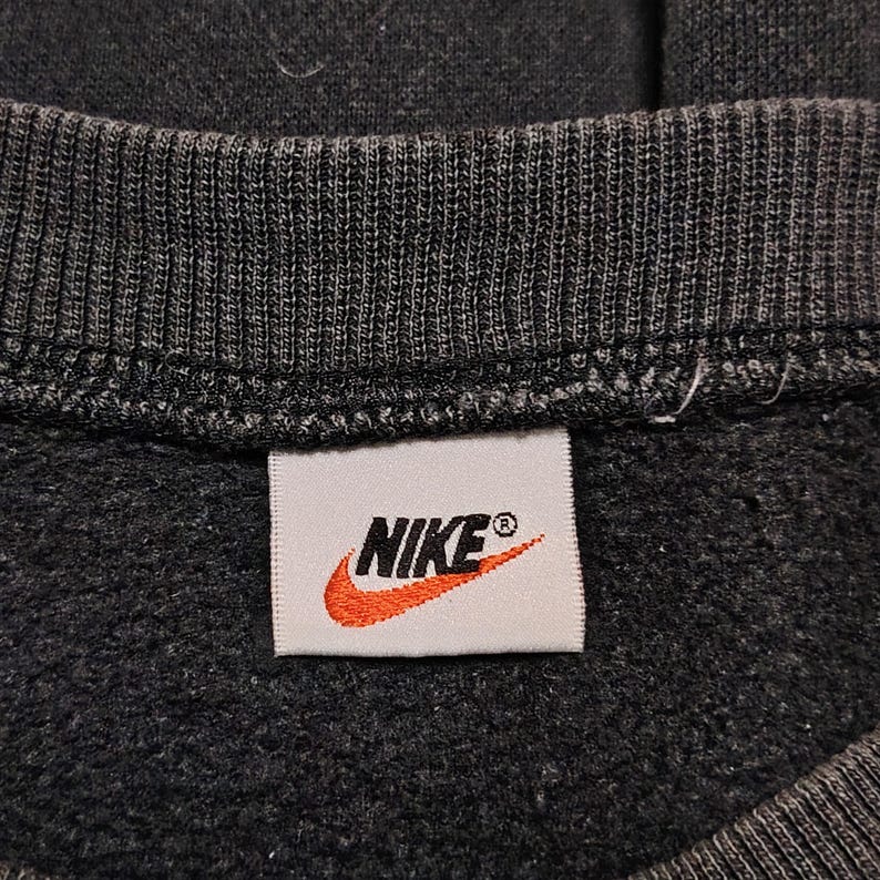 Vintage Nike crewneck sweatshirt featuring iconic spellout logo in classic black, Y2K sportswear style with relaxed unisex fit, perfect for streetwear, casual everyday wear, and vintage Nike collectors worldwide.