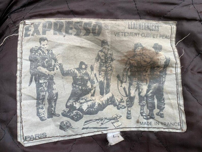May include: A white patch with black text and a black and white illustration of soldiers. The text reads "EXPRESSO&reg; LEATHERJACKS VETEMENT CUIR ET PEAU PARIS MADE IN FRANCE".