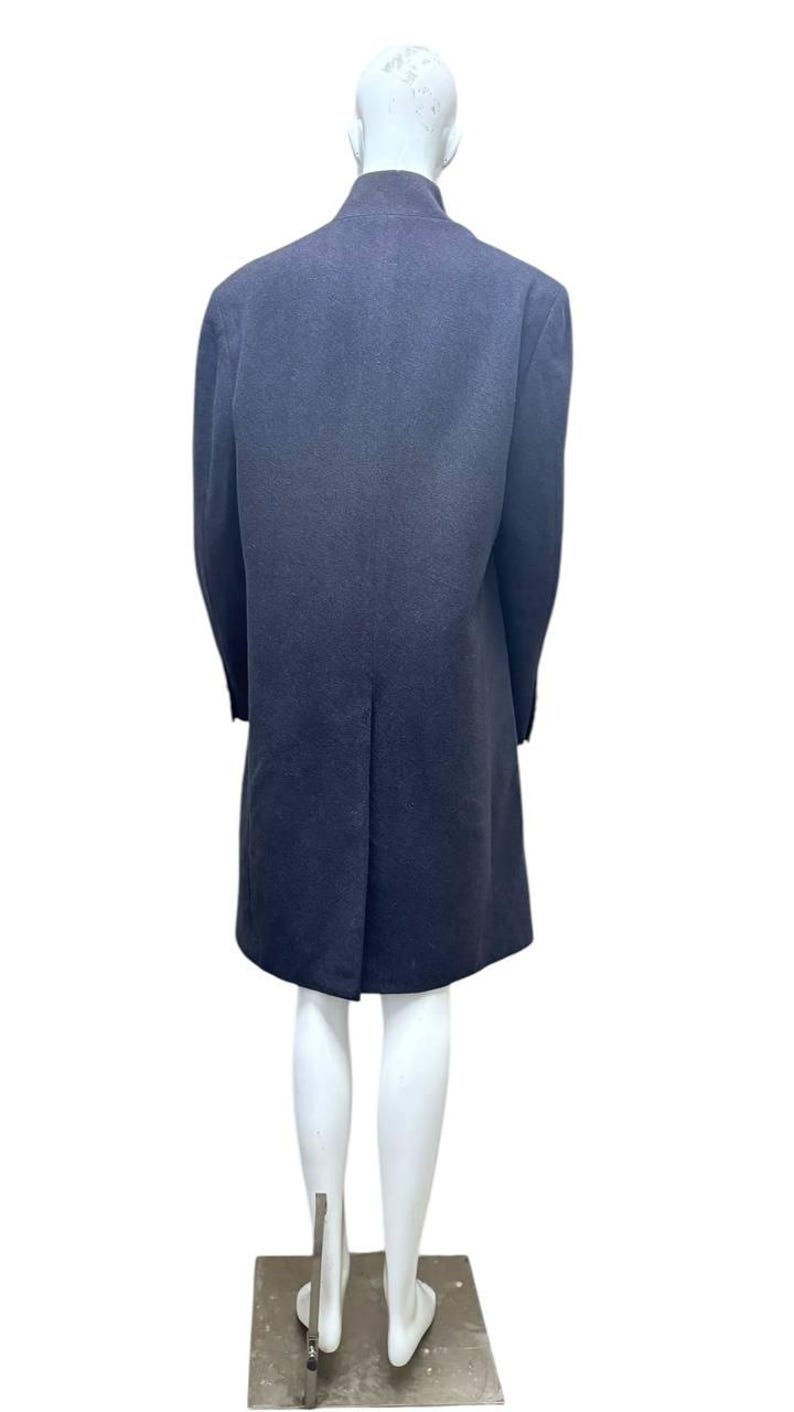 May include: A long, dark blue coat with a high collar and a single back vent. The coat is on a white mannequin.