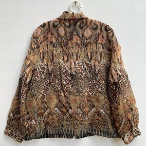 May include: A brown and beige long-sleeved button-up shirt with a leopard print and paisley pattern.