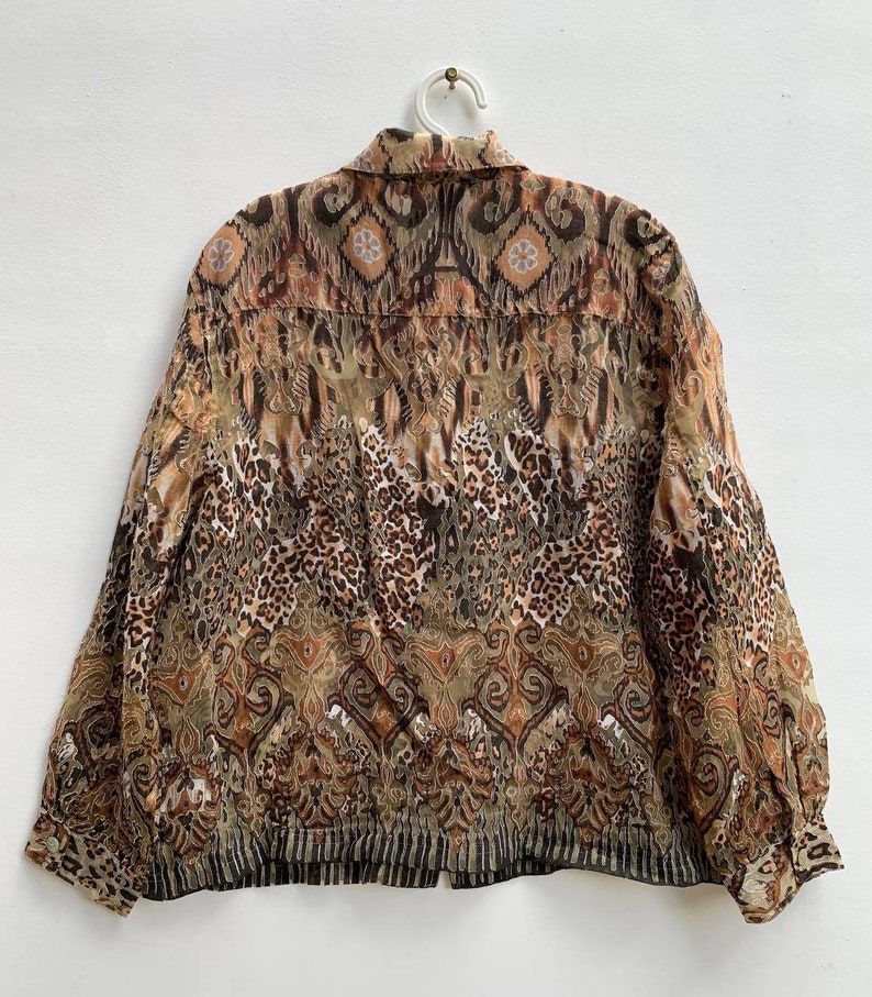 May include: A brown and beige long-sleeved button-up shirt with a leopard print and paisley pattern.