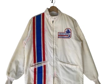 May include: A white vintage Honda racing jacket with a blue and red stripe down the left side and a Honda logo on the right chest. The jacket has a zipper closure and two pockets.