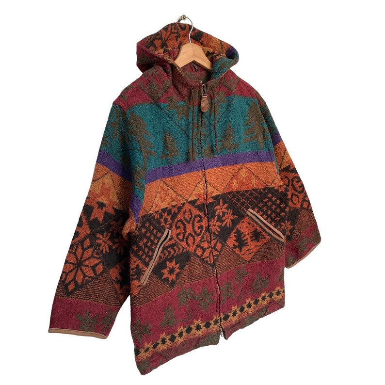 May include: A colorful hooded jacket with a zipper closure. The jacket features a geometric pattern in shades of orange, red, green, blue, and purple.