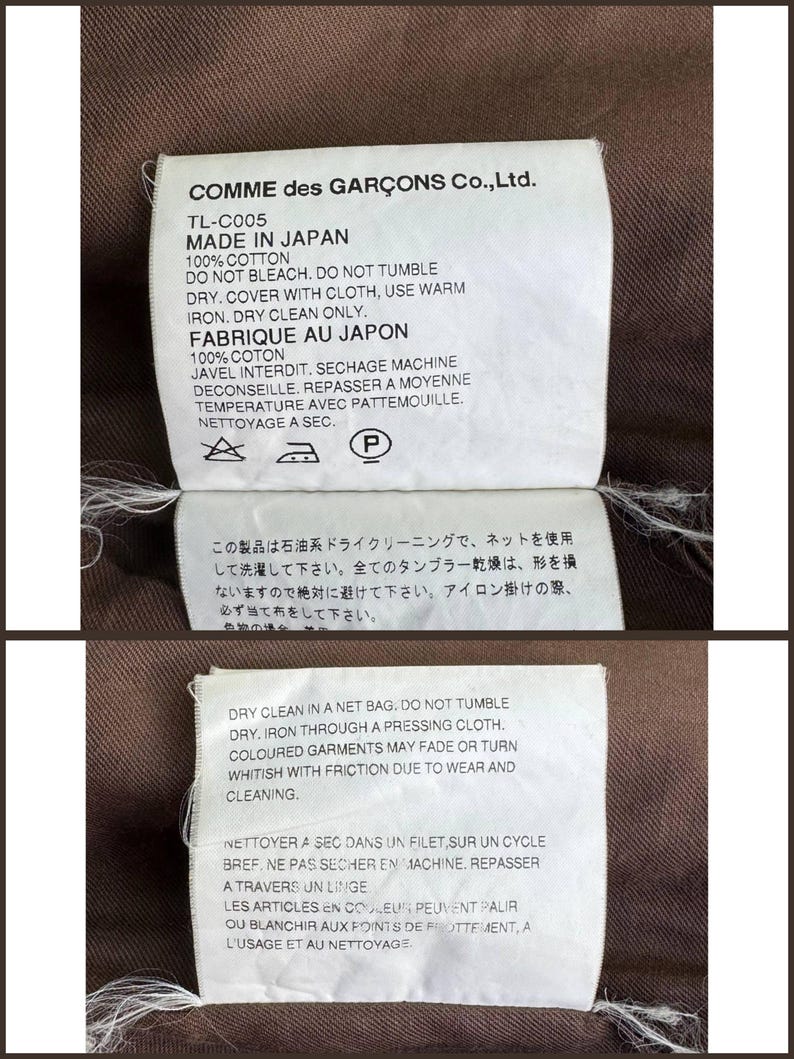 May include: Three white fabric tags with black text, attached to a brown garment. The tags provide care instructions, including "Made in Japan," "100% Cotton," and dry cleaning details. The brand name "COMME des GAR&Ccedil;ONS" is visible.