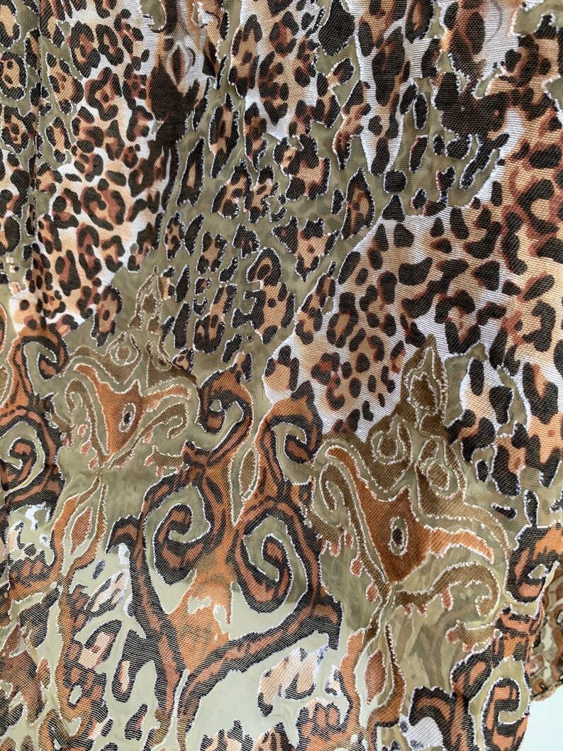 May include: A brown and green fabric with a leopard print and a paisley pattern.