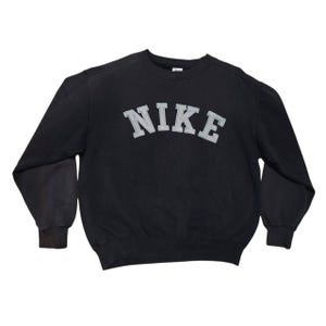Vintage Nike crewneck sweatshirt featuring iconic spellout logo in classic black, Y2K sportswear style with relaxed unisex fit, perfect for streetwear, casual everyday wear, and vintage Nike collectors worldwide.