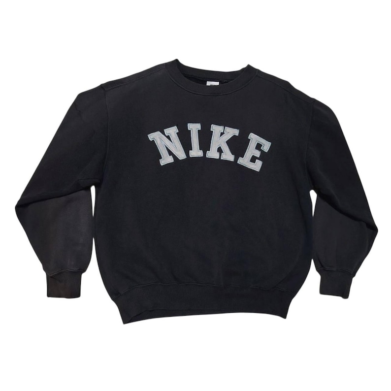 Vintage Nike crewneck sweatshirt featuring iconic spellout logo in classic black, Y2K sportswear style with relaxed unisex fit, perfect for streetwear, casual everyday wear, and vintage Nike collectors worldwide.
