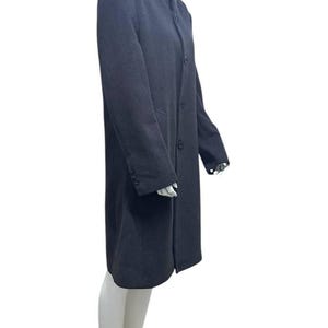 May include: A long-sleeved charcoal gray coat with a mandarin collar and a single button closure.