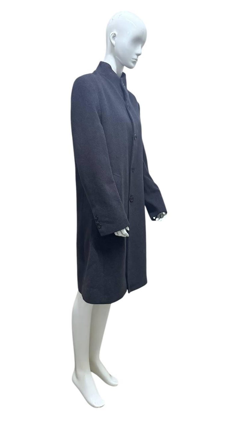 May include: A long-sleeved charcoal gray coat with a mandarin collar and a single button closure.